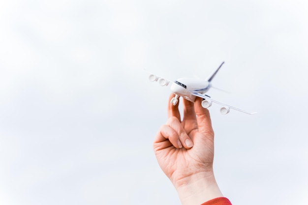 Pequeño avión de juguete volando en el cielo en la mano del hombre Símbolo del fin de la cuarentena y el autoaislamiento debido a la pandemia del coronavirus covid19 Apertura de fronteras entre países y comienzo de vuelos