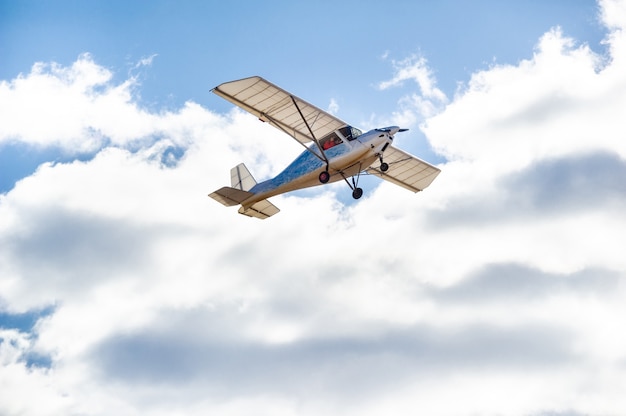Un pequeño avión monomotor sobrevolando contra el cielo azul