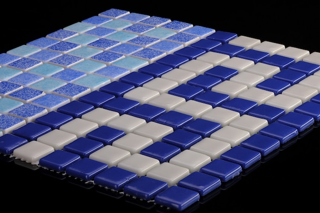 Pequeño azulejo de cerámica azul sobre un fondo negro, mayólica. para el catálogo