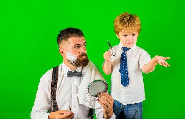 Pequeno barbeiro filho e pai barbear assistente para o pai barbearia conceito dia dos pais dia da família