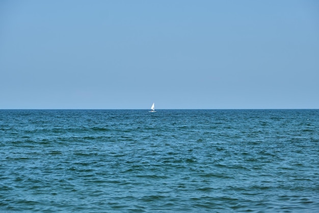 Pequeno barco branco navegando em um belo mar turquesa