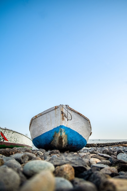 Pequeno barco de pesca em costa rochosa