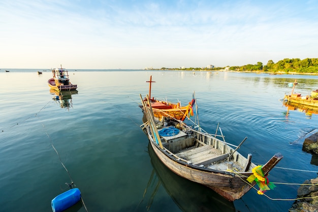 Foto pequeno barco de pesca na praia por do sol