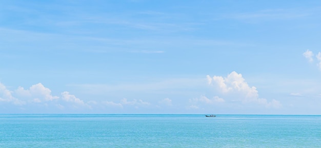 Pequeno barco de pesca tradicional mínimo no mar azul e nuvens do céu na temporada de verão