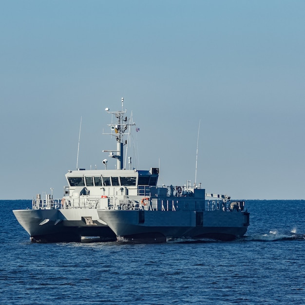 Foto pequeño barco militar gris moviéndose desde el mar báltico