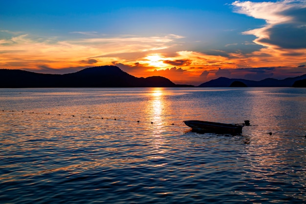 Pequeño barco de pesca en el paisaje del mar al atardecer