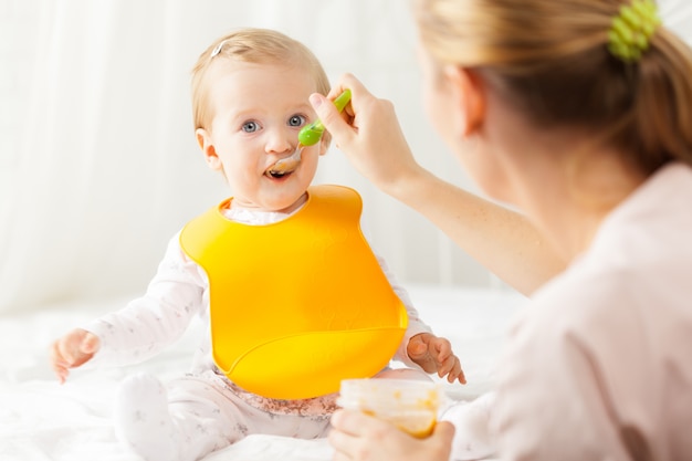 Pequeño bebé alimentándose con una cuchara