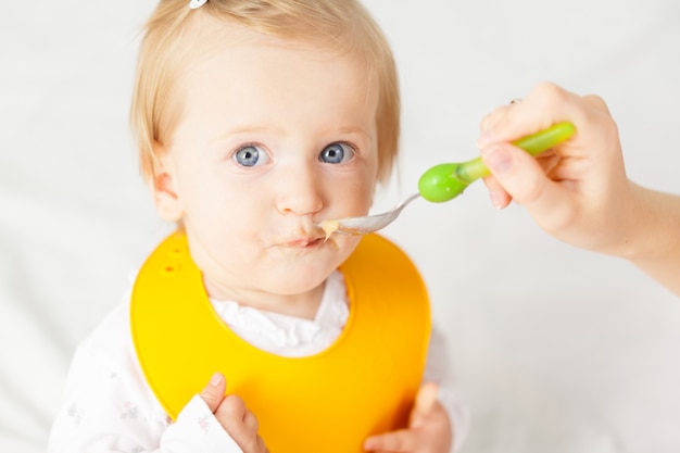 Foto pequeño bebé alimentándose con una cuchara