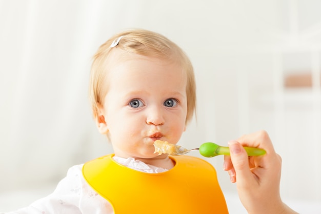 Pequeño bebé alimentándose con una cuchara