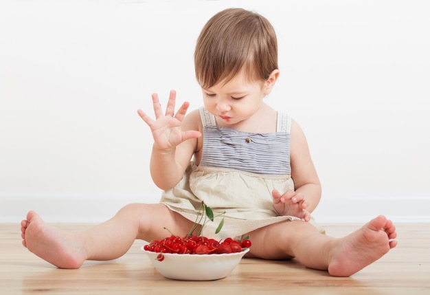 Pequeño bebé comiendo bayas