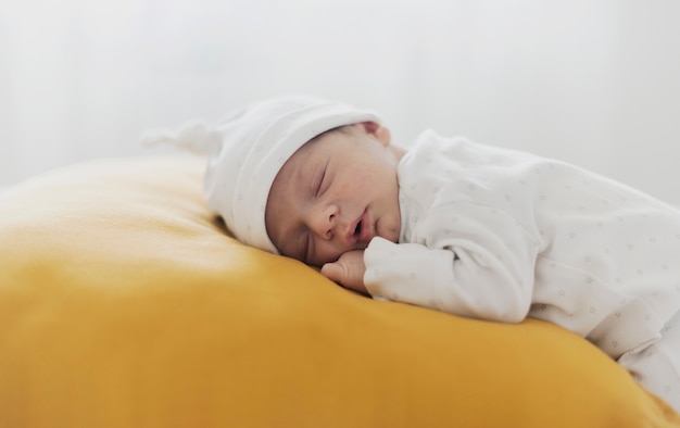 Foto pequeño bebé durmiendo sobre una almohada amarilla