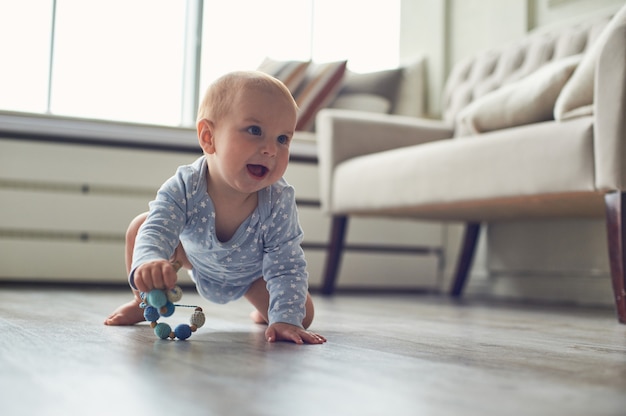 Pequeño bebé gateando en el piso en casa