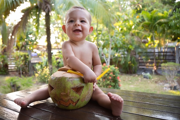 pequeño bebé infantil saca paja de coco verde que está hecho en forma de símbolo de halloween