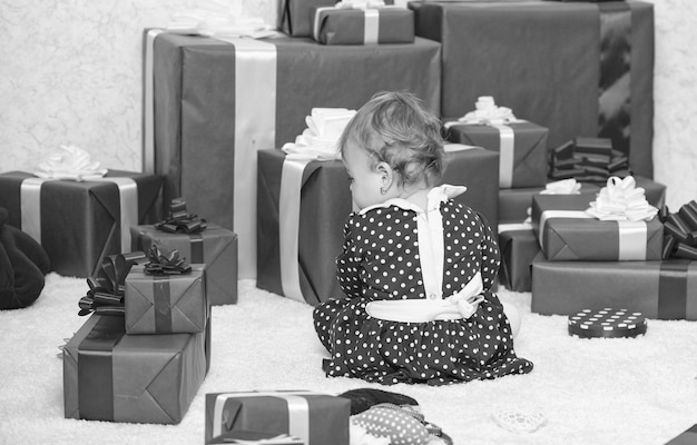 El pequeño bebé juega cerca de la pila de cajas de regalo rojas envueltas Mi primera Navidad Compartiendo la alegría de la primera Navidad del bebé con la familia El evento de la primera Navidad del bebé una vez en la vida Regalos para la primera Navidad del niño