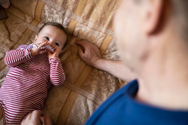 Pequeño bebé jugando con su abuelo