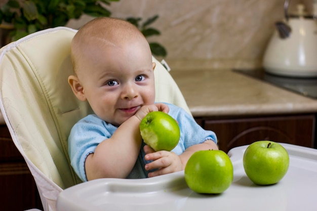 Pequeño bebé lindo que come la manzana verde