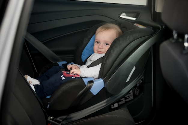 Pequeño bebé sonriente en el asiento trasero