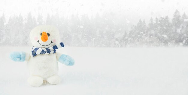 Pequeno boneco de neve em um fundo de inverno com espaço de cópia. Fundo de Natal. Cartão de ano novo. Bandeira.