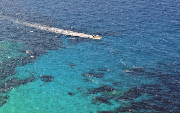 Pequeño bote en un mar turquesa en la isla de Córcega