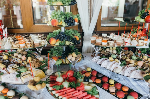 Pequeno buffet de casamento com diferentes sobremesas e frutas.