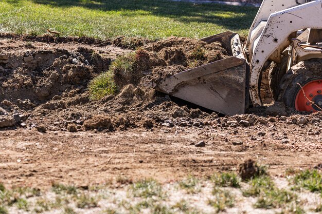 Foto pequeno bulldozer cavando no quintal para instalação de piscina