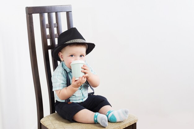 Pequeño caballero con sombrero se sienta en la silla