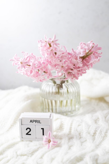 Un pequeño calendario con flores rosas sobre un fondo blanco.