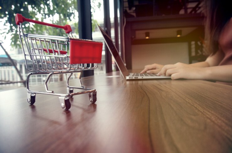 Foto pequeño carrito de la compra con el ordenador portátil y la tarjeta de visita espacio de copia espacio para el concepto de compras en línea.
