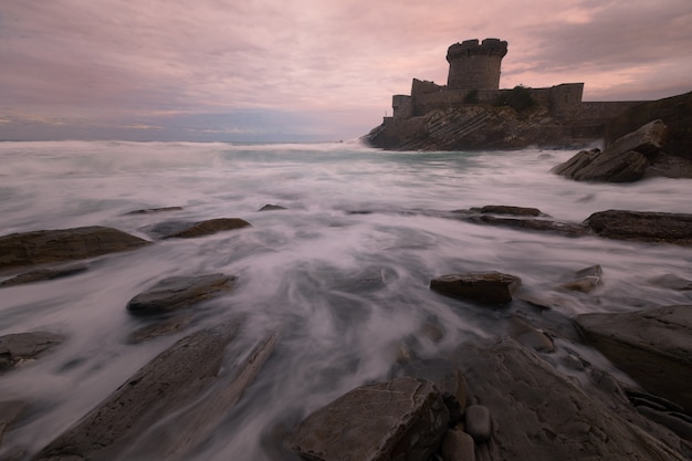 Foto pequeno castelo cercado pelo corajoso oceano atlântico em sokoa (socoa) na baía de donibane lohitzune (saint jean de luz) no país basco.