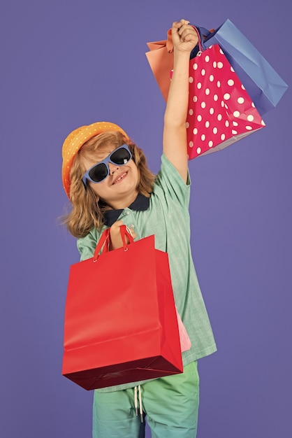 Pequeno cliente comprador Criança fazendo compras Retrato de menino com sacolas de compras Criança da moda