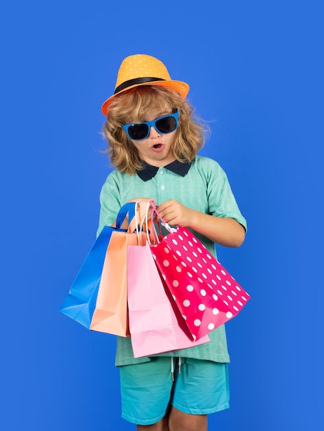 Pequeño cliente comprador emocionado Niño de compras Retrato de un niño con bolsas de compras Niño de moda