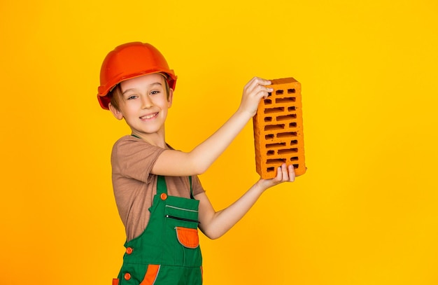 Foto pequeno construtor de capacete criança vestida como um trabalhador de construção menino usando capacete criação de criança