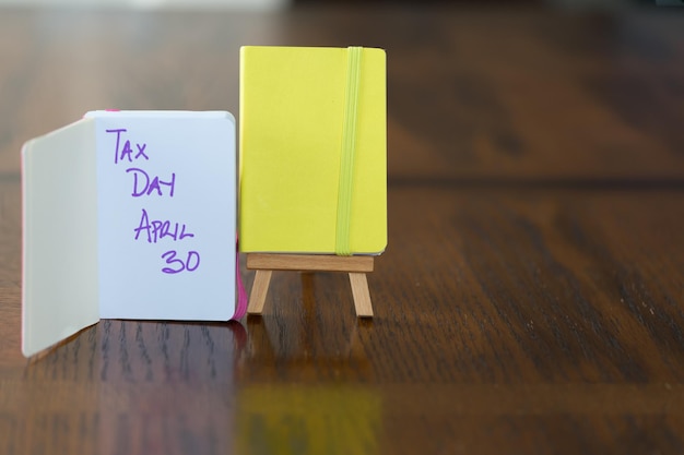 Pequeño cuaderno amarillo en soporte de caballete