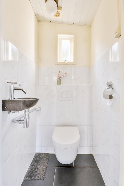 Un pequeño cuarto de baño de estilo blanco y negro con inodoro y lavabo con bisagras en un apartamento moderno