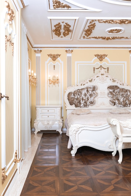 Pequeño dormitorio de lujo con baño y muebles caros en un elegante estilo barroco antiguo.