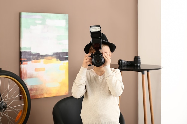 Pequeño fotógrafo lindo con cámara profesional en casa