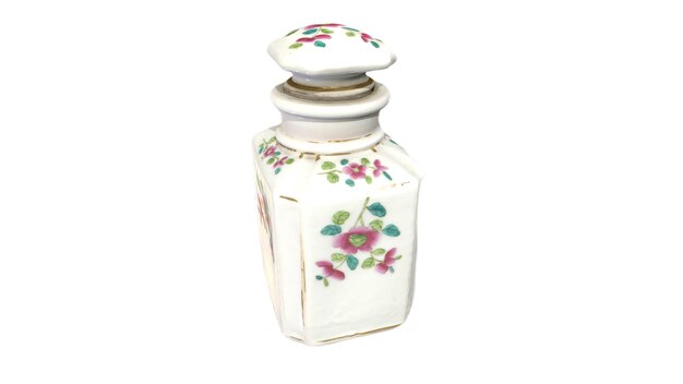 Un pequeño frasco de perfume con un diseño floral en la parte superior.