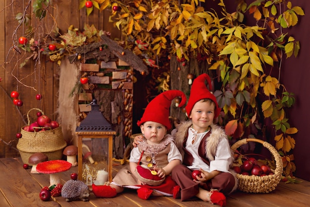 Pequeno gnomo de conto de fadas, menina e menino brincando e coletando abóboras, comendo maçãs