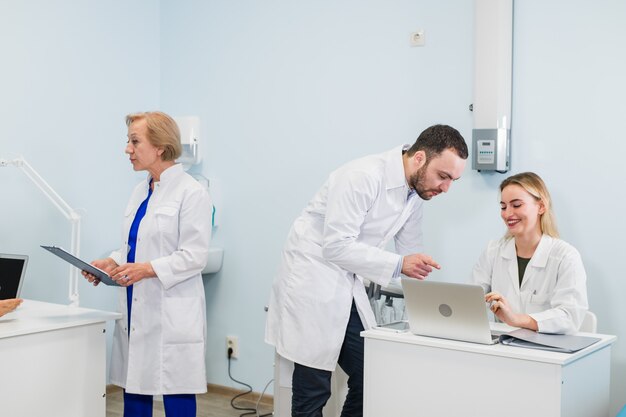 Pequeno grupo de médicos trabalhando juntos no consultório médico.