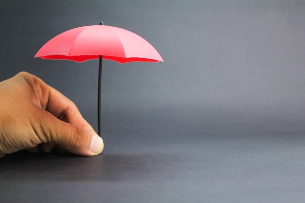 pequeno guarda-chuva vermelho com um fundo escuro conceito de cobertura de seguro