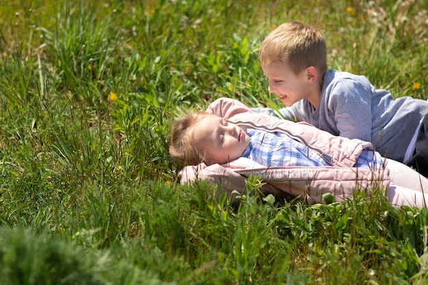 Pequeño hermano y hermana jugando juntos afuera