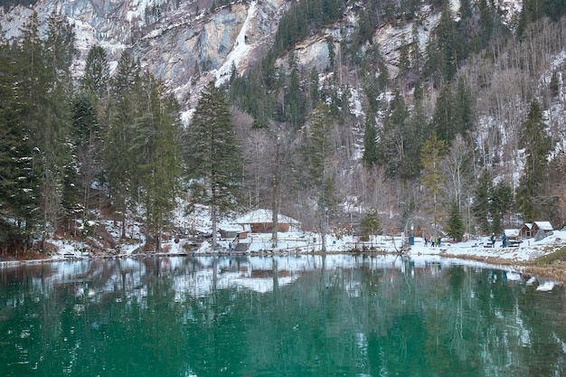 Pequeño lago de aguas turquesas en un entorno nevado conocido como lago Blausee en Suiza