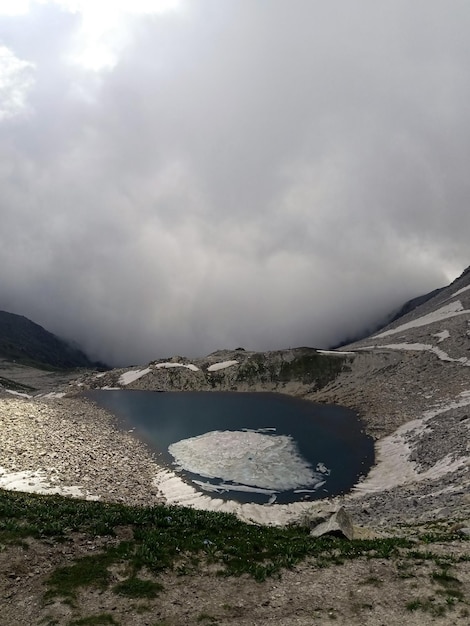 Pequeño lago congelado en la cima de una montaña rocosa