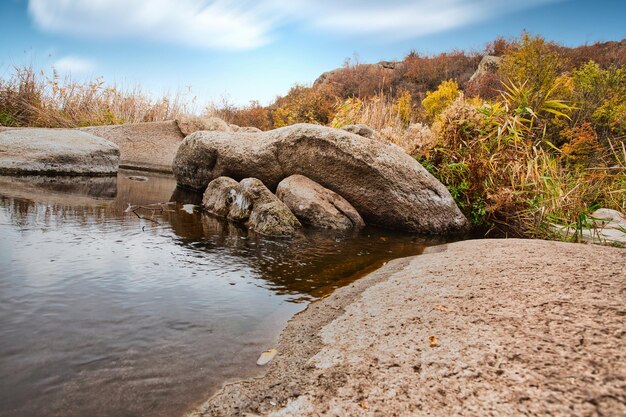 Un pequeño lago maravilloso a lo largo de un pintoresco río que fluye a través de un hermoso cañón Enormes escotillas están en el agua Ucrania