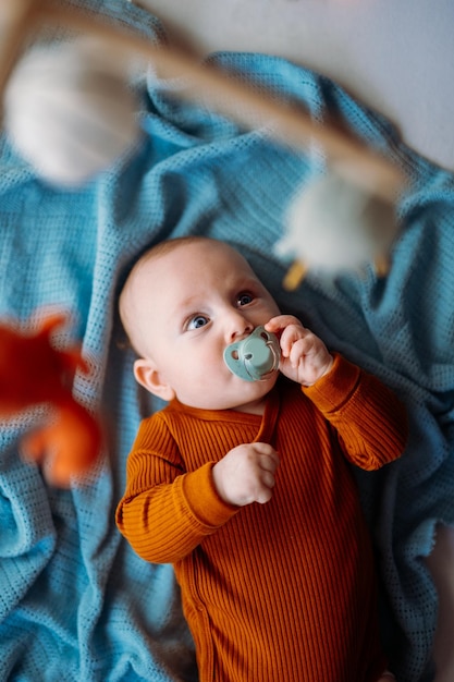 Pequeño y lindo bebé jugando con juguetes en casa sonriendo a la cámara foto vertical de invierno