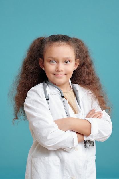 Pequeno médico feliz de jaleco cruzando os braços no peito