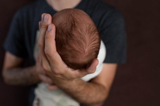 pequeno menino recém-nascido encantador nos braços de seu pai 039s fundo neutro foto de estúdio de um recém- nascido