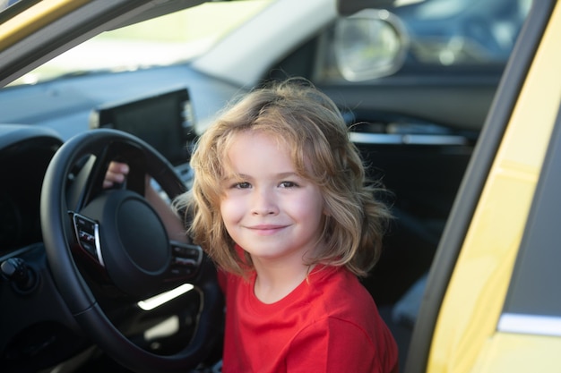 Pequeno motorista Menino bonito fingindo dirigir Menino conduzindo carro Menino está sentado ao volante Menino brincando com carro Sonho imaginação infância conceito de viagem e férias