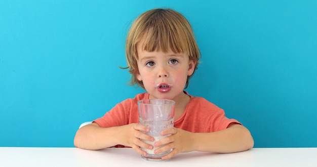 Foto el pequeño muchacho lindo está bebiendo la leche