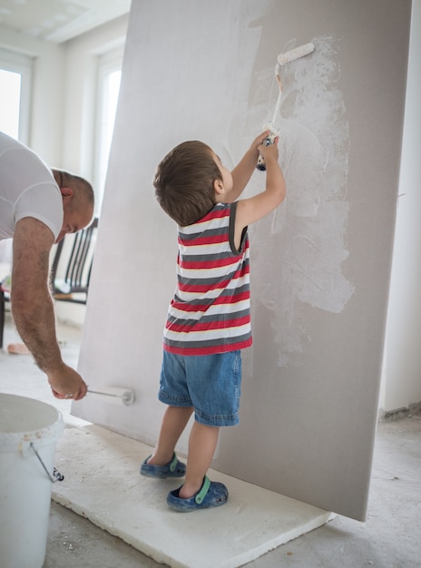 Pequeño muchacho lindo que pinta en una pared